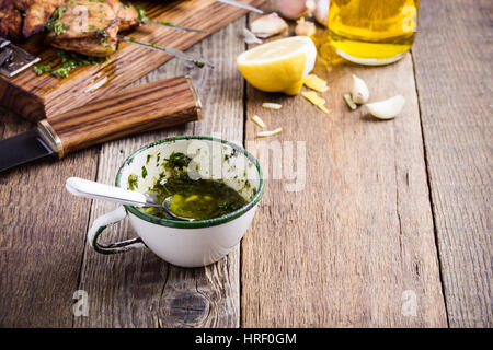 Sauce chimichurri maison blanche en milieu rural mug sur la table en bois rustique, traditionnelle ou sauce marinade pour la viande grillée Banque D'Images