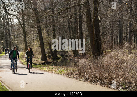 Un jeune couple à vélo dans un parc sur une journée froide. Tiergarten, Berlin, Allemagne Banque D'Images