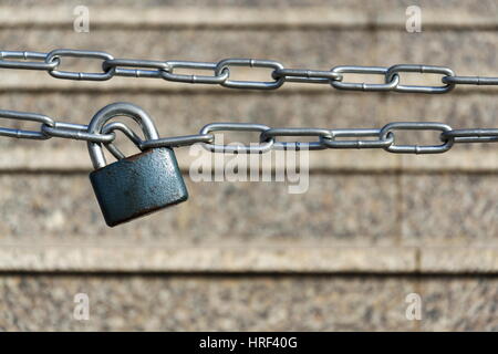 Cadenas bleu métallique est suspendu sur la chaîne de fer d'argent avec des escaliers Banque D'Images