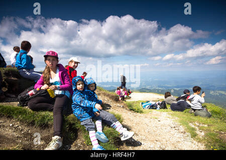 Les enfants ont une collation après une longue randonnée en montagne Banque D'Images