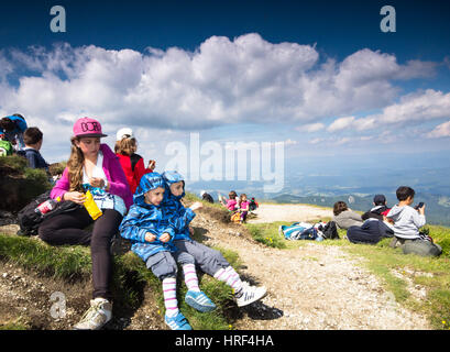 Les enfants ont une collation après une longue randonnée en montagne Banque D'Images