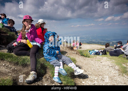 Les enfants ont une collation après une longue randonnée en montagne Banque D'Images