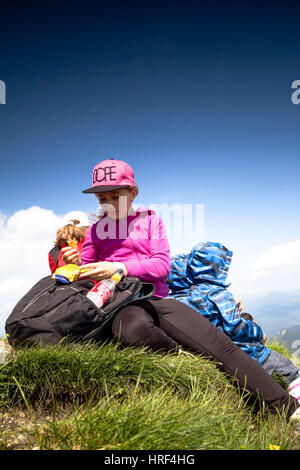 Les enfants ont une collation après une longue randonnée en montagne Banque D'Images