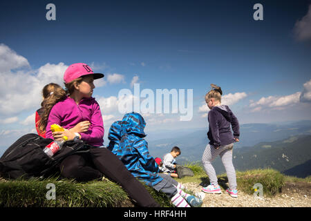 Les enfants ont une collation après une longue randonnée en montagne Banque D'Images