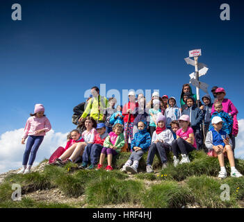 Les enfants ont une collation après une longue randonnée en montagne Banque D'Images