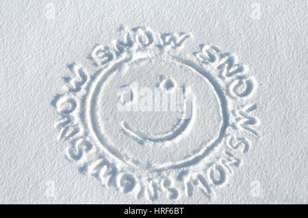 Handrawn 'smiley face' est entouré par les mots 'snow.' Tous sont tirés sur une nouvelle couche de neige du Colorado. Banque D'Images