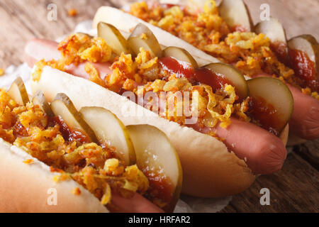 Alimentaire danois : hot dog avec oignons croustillants et concombres close-up sur la table horizontale. Banque D'Images