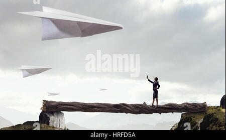 Femme élégante et big Paper Plane flying in sky. Technique mixte Banque D'Images