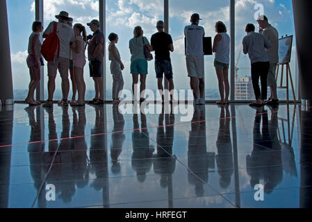 Les touristes de prendre des photos de la vue de la Saigon Skydeck dans la Bitexco Financial Tower et se reflètent sur le sol sur une journée ensoleillée avec ciel bleu. Banque D'Images