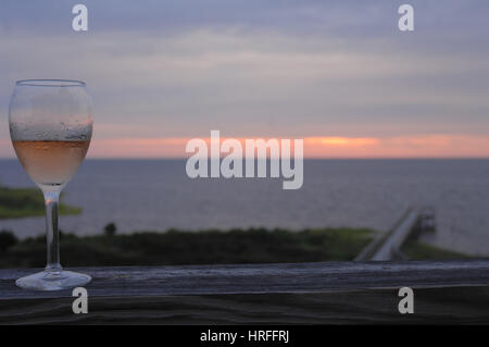 Verre à vin sur le pont au coucher du soleil Pamlico Sound, Outer Banks, Caroline du Nord. Banque D'Images