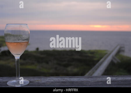 Verre à vin sur le pont au coucher du soleil Pamlico Sound, Outer Banks, Caroline du Nord. Banque D'Images