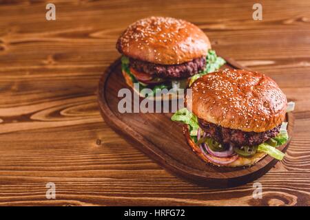 Deux nouveaux burgers sur table en bois Banque D'Images