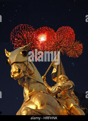 La nuit image de statue en bronze de Jeanne d'Arc sur la Rue de Rivoli à Paris avec Fireworks rouge en arrière-plan. Banque D'Images