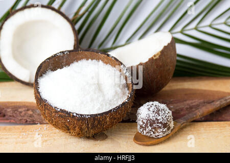 Poudre de noix de coco dans un shell naturelle avec des feuilles Banque D'Images