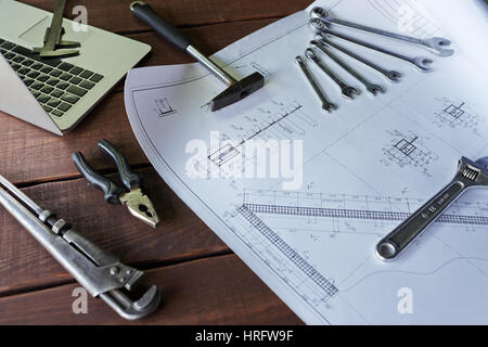 Libre tourné d'assortiment d'outils de mécanique, clés, pinces, marteau et disposés sur les plans de table en bois avec des systèmes de voiture et ordinateur portable à proximité. Banque D'Images