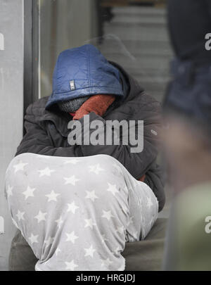 Un sdf est assis devant une boutique à Francfort/Main, Allemagne, 19 février 2017. Le 57-year-old Thomas Adam a passé 20 ans avec des interruptions dans la rue. Il parle de son expérience au cours des visites de la ville grâce à Francfort. Photo : Arne Dedert/dpa Banque D'Images