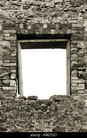 Ruines de calcaire rustique en pierre de maçonnerie mur boulder décombres et ruines vide vide sépia isolé du cadre de la fenêtre d'ouverture de l'ouverture de la brique ancienne patiné Banque D'Images