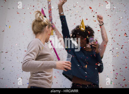 Multiethnics parti confettis jeunes heureux nouvel an fête de groupe en dansant et s'amuser à la maison Banque D'Images