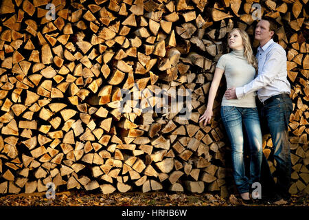 Junges Liebespaar, parution du modèle an einen Holzstapel gelehnt - jeune couple s'appuyant sur une pile de bois Banque D'Images