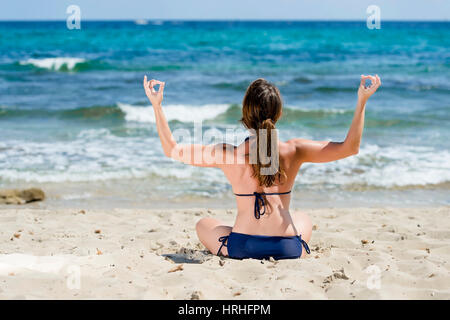 Frau im Bikini Joga macht am Strand, Spanien, Ibiza - femme ne le yoga à la plage, Ibiza, Espagne Banque D'Images