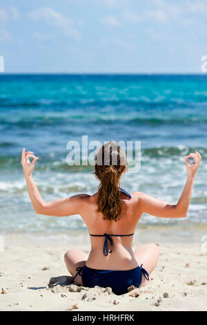 Frau im Bikini Joga macht am Strand, Spanien, Ibiza - femme ne le yoga à la plage, Ibiza, Espagne Banque D'Images