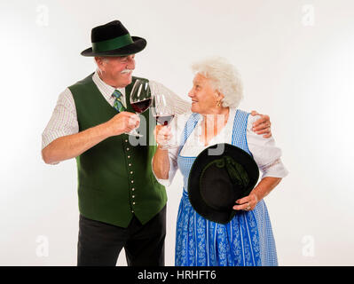 Dans Rotweinglaesern Seniorenpaar mit Tracht - couple en costume traditionnel Banque D'Images