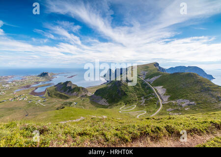 Route raide de courbes entre prés verts et mer, Sorland, l'île de Vaeroy, comté de Nordland, îles Lofoten, Norvège Banque D'Images