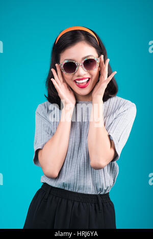 Full body of asian woman habillé en robe de style pin-up portant des lunettes plus de bleu. Banque D'Images