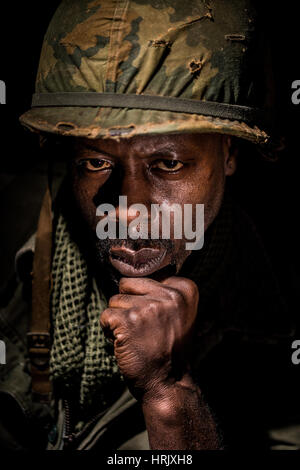 Portrait d'un soldat afro-américain de la guerre du Vietnam, contre un fond noir. Dark Shadows utilisé pour une image plus dramatique. Banque D'Images