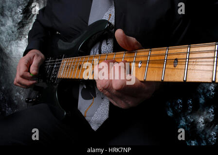 Jouer à la main sur le cou de la guitare Banque D'Images