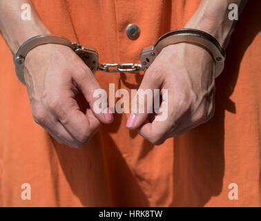 Woman wearing handcuffs et prison orange jumpsuit Banque D'Images