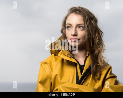 Jeune femme en veste de pêche jaune Banque D'Images