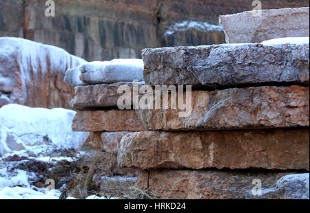 Grande carrière de marbre sans peuple avec les énormes blocs de marbre rouge extrait de la montagne en hiver avec de la neige Banque D'Images