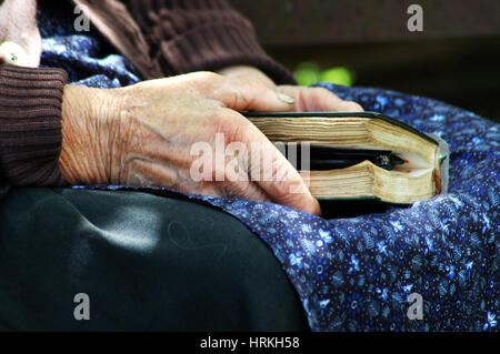 RAMETI, ROUMANIE - juin 6, 2010 : l'Aîné femme tenant une Bible dans sa main. Les générations plus âgées dans les zones rurales de la Roumanie sont très religieux Banque D'Images