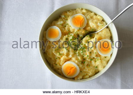 Un savoureux bol de salade aux œufs et de pommes de terre bavaroise avec une cuillère Banque D'Images