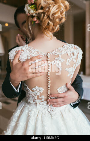 Part du marié embrasse doucement la taille de la mariée, méconnaissable close-up Banque D'Images