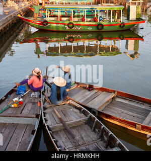 Les femmes vietnamiennes sont assises sur leurs bateaux amarrés ensemble sur la rivière Thu bon dans la ville antique de Hoi an. Hoi an, province de Quang Nam, Vietnam. Banque D'Images