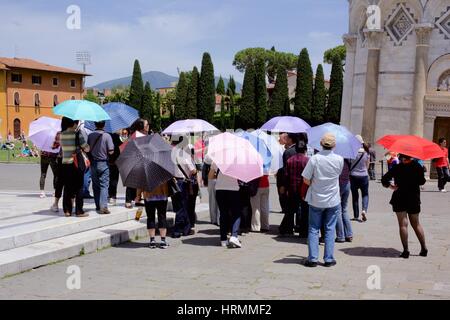 Les touristes à Piazza dei Miracle, Pise, Italie avec des parapluies ouverts au soleil Banque D'Images