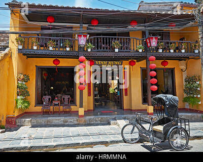 Tricycle ancien en face de l'hôtel Vinh Hung dans l'ancienne ville de Hoi An. Province de Quang Nam, Vietnam. Banque D'Images