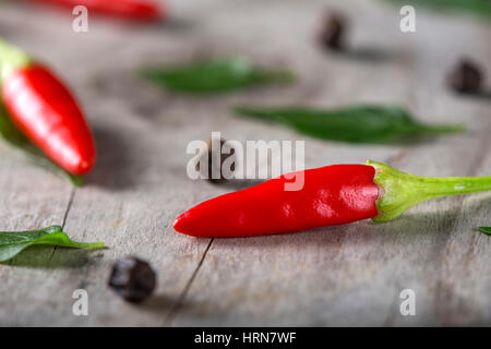 Red Hot Chili sur fond de bois avec des herbes Banque D'Images