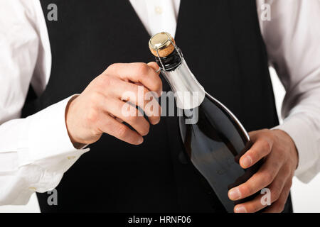 Waiter déboucher une bouteille de champagne Banque D'Images