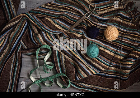 Fragment de tricots faits main, des aiguilles à tricoter et des pelotes de laine sur Tableaux blancs peints Banque D'Images