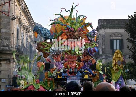 Acireale (CT), Italie - Février 28, 2017 : flotteur allégorique, représentant d'une grosse tête et d'autres caractères dans la forme de légumes, lors de défilé de carnaval Banque D'Images