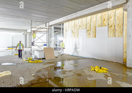 Les travailleurs sont assemblée générale mur de gypse. Plâtre est en construction à l'aide d'un échafaudage mobile. Banque D'Images