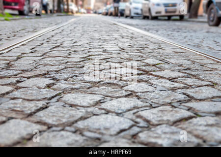 Vieilles lignes de chemin de fer sur la surface de la route pavée Banque D'Images