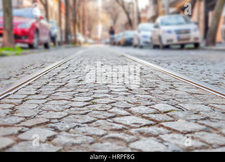 Vieilles lignes de chemin de fer sur la surface de la route pavée Banque D'Images