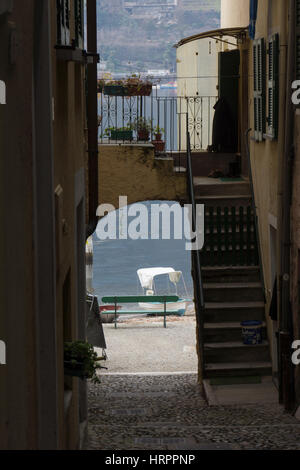 Petit bateau sur un rivage vu à travers une rue étroite avec passage voûté sur Isola dei Pescatori, Isola Superiore en lac Majeur, Italie du Nord Banque D'Images