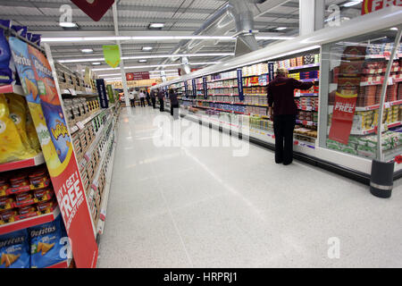 Supermarché Sainsburys dans Colne , Royaume-Uni. Un travailleur féminin sur les allées Banque D'Images