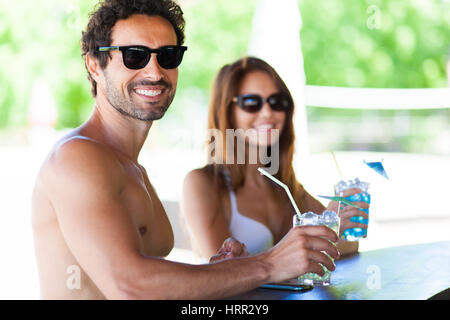 Heureux couple having cocktails en vacances Banque D'Images