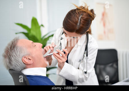 Contrôle d'un médecin de la gorge du patient Banque D'Images